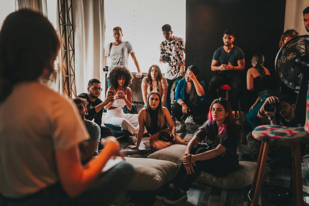 A casual group of people sit around attentively