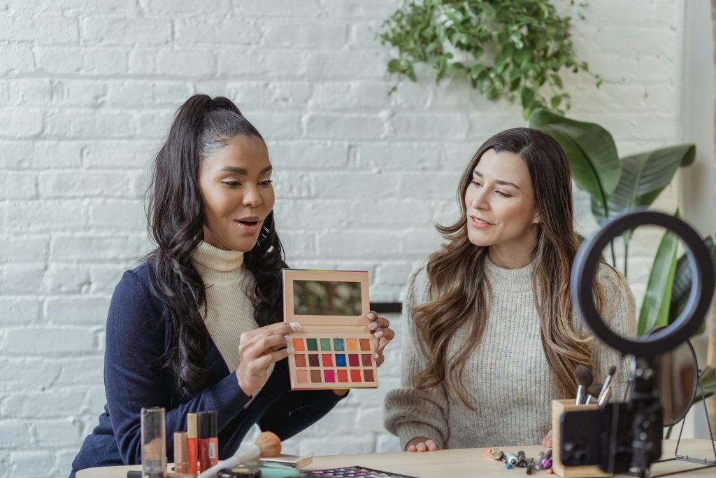 Two friends show makeup palette during demonstration