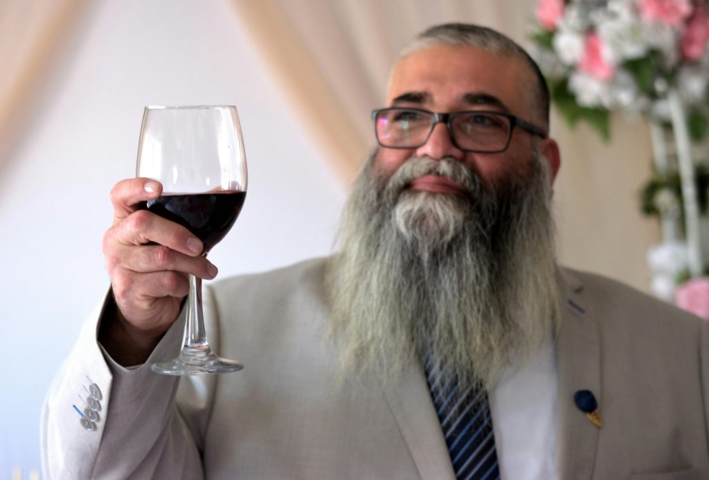 Older gentleman raising a glass of wine