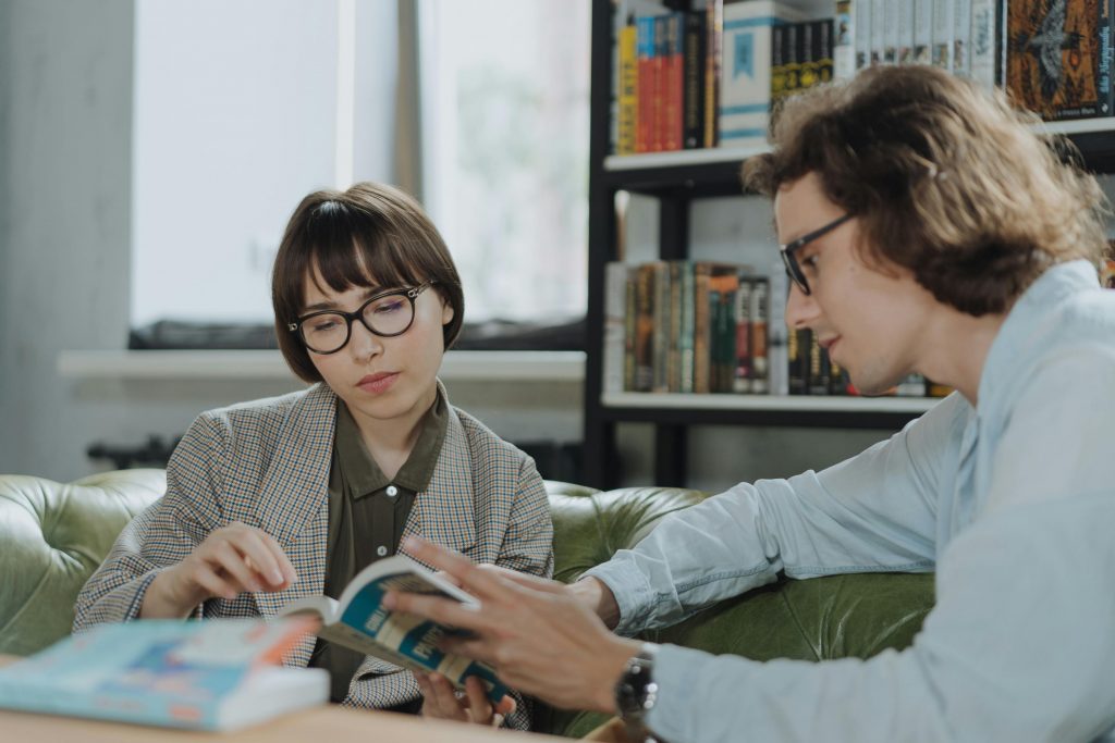 two students research in the library